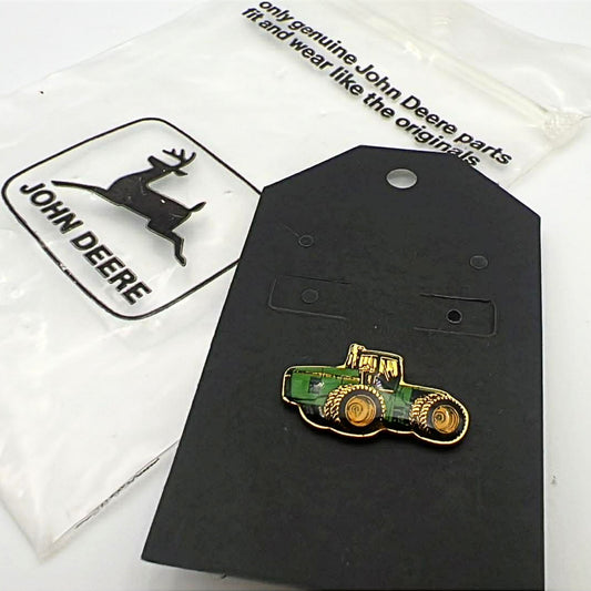 John Deere tractor enamel lapel pin displayed on original backing card with branded packaging, featuring green and yellow farm tractor design with gold tone metal, collectible farming pin for hats, jackets, or rural western style outfits