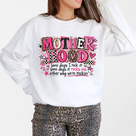 Woman modeling oversized white Mother Hood graphic sweatshirt with pink leopard print typography and funny motherhood quote in trendy casual outfit.