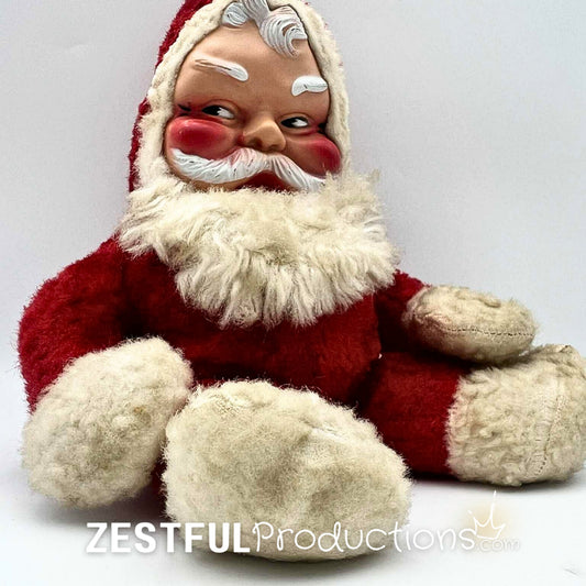 Side angle of vintage Santa Claus plush doll in Rushton style with rosy cheeks, red plush suit, and fluffy white trim. Mid century modern Christmas collectible ideal for retro holiday decor and nostalgic seasonal displays.
