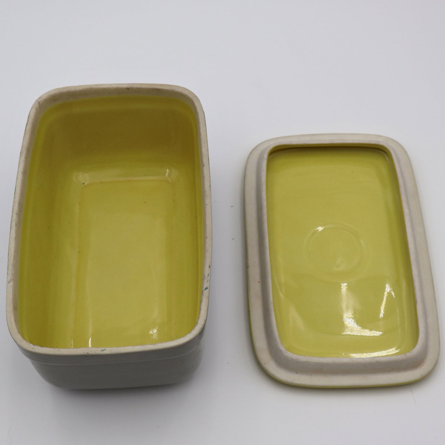 Open vintage GE refrigerator dish with lid showing ceramic storage capacity and mid century design.
