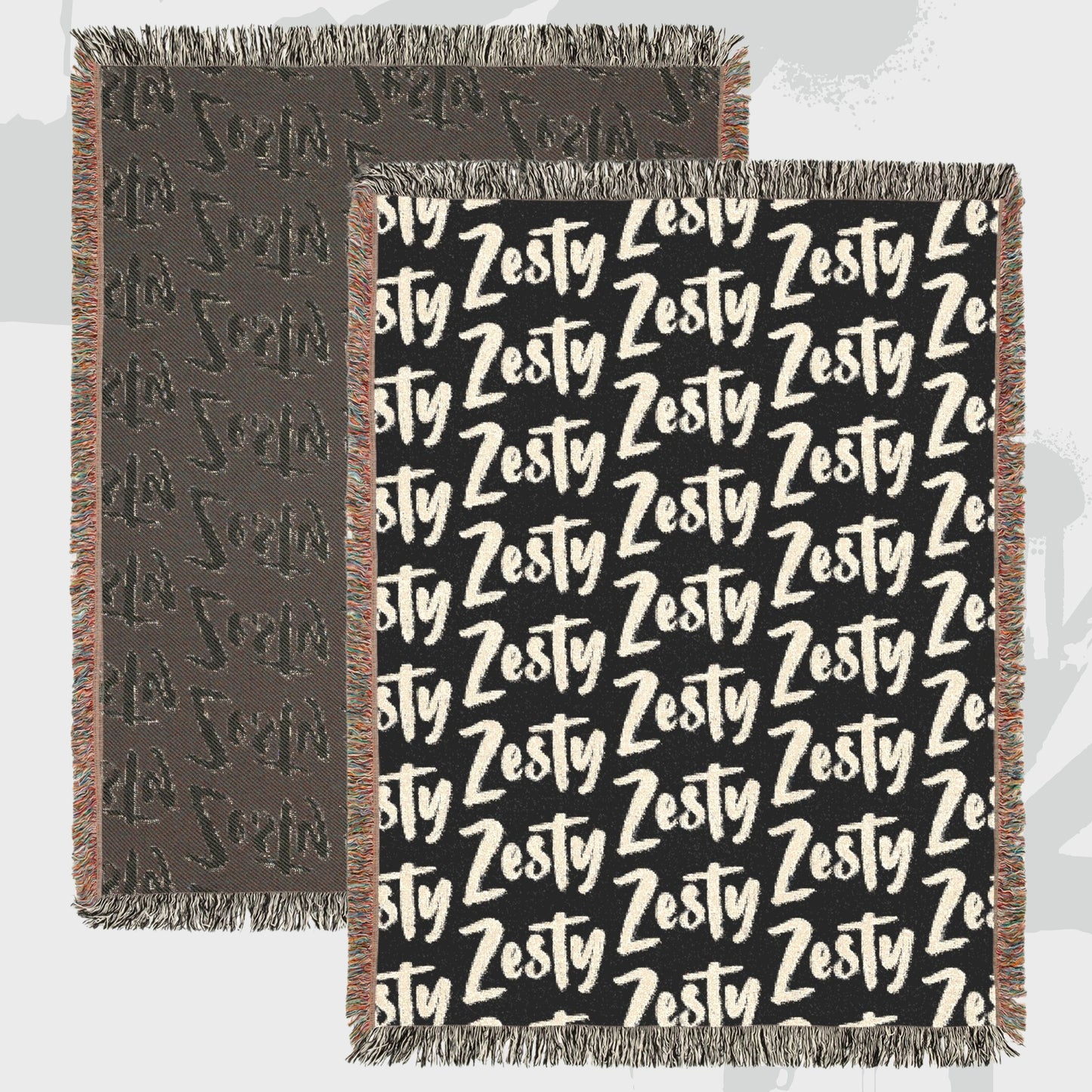 Close-up of woven cotton throw blanket showing bold Zesty text pattern