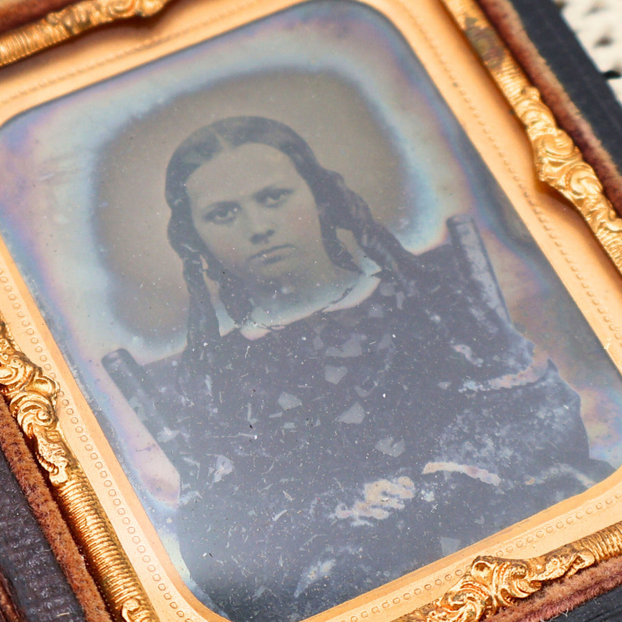 Authentic antique 1/6 plate Civil War era ambrotype portrait displayed inside its original ornate thermoplastic Union case. The open case reveals an embossed velvet lining, decorative gilt brass mat, and nineteenth-century glass portrait, showcasing early American photographic craftsmanship and Victorian design.