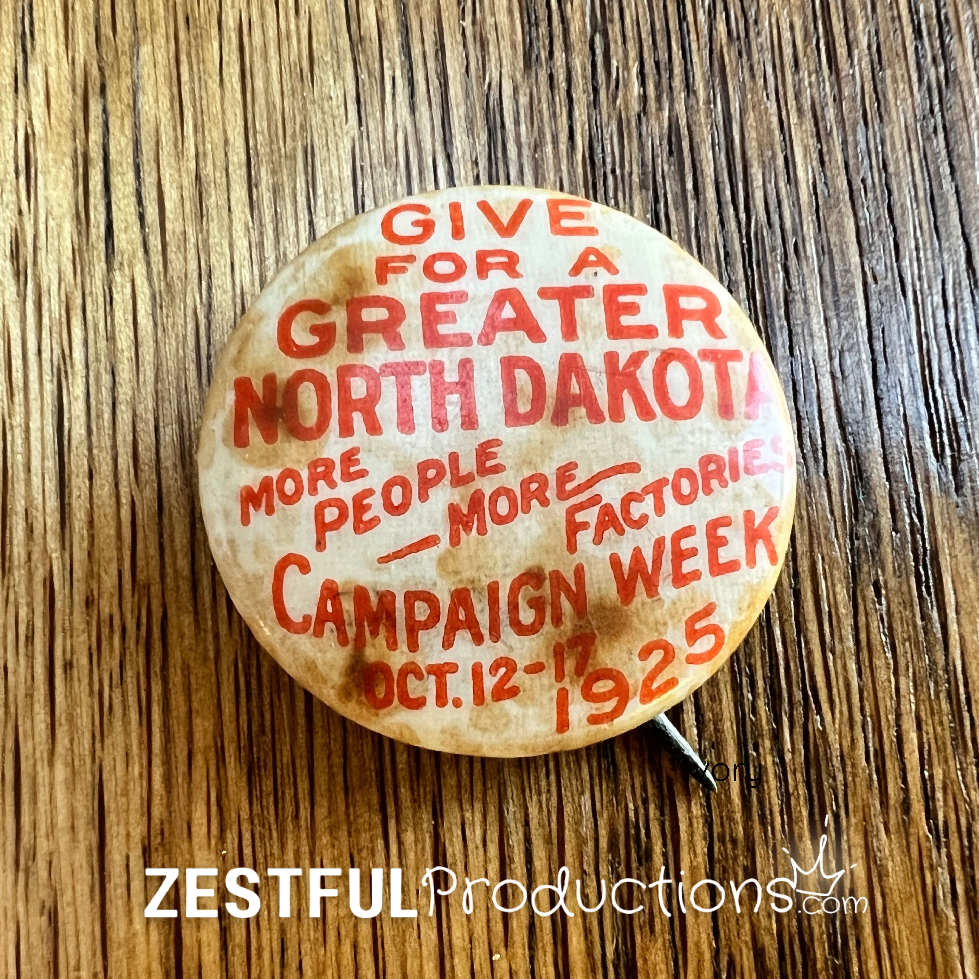 Front of rare 1925 “Give for a Greater North Dakota” Campaign Week button with red lettering on cream celluloid background.