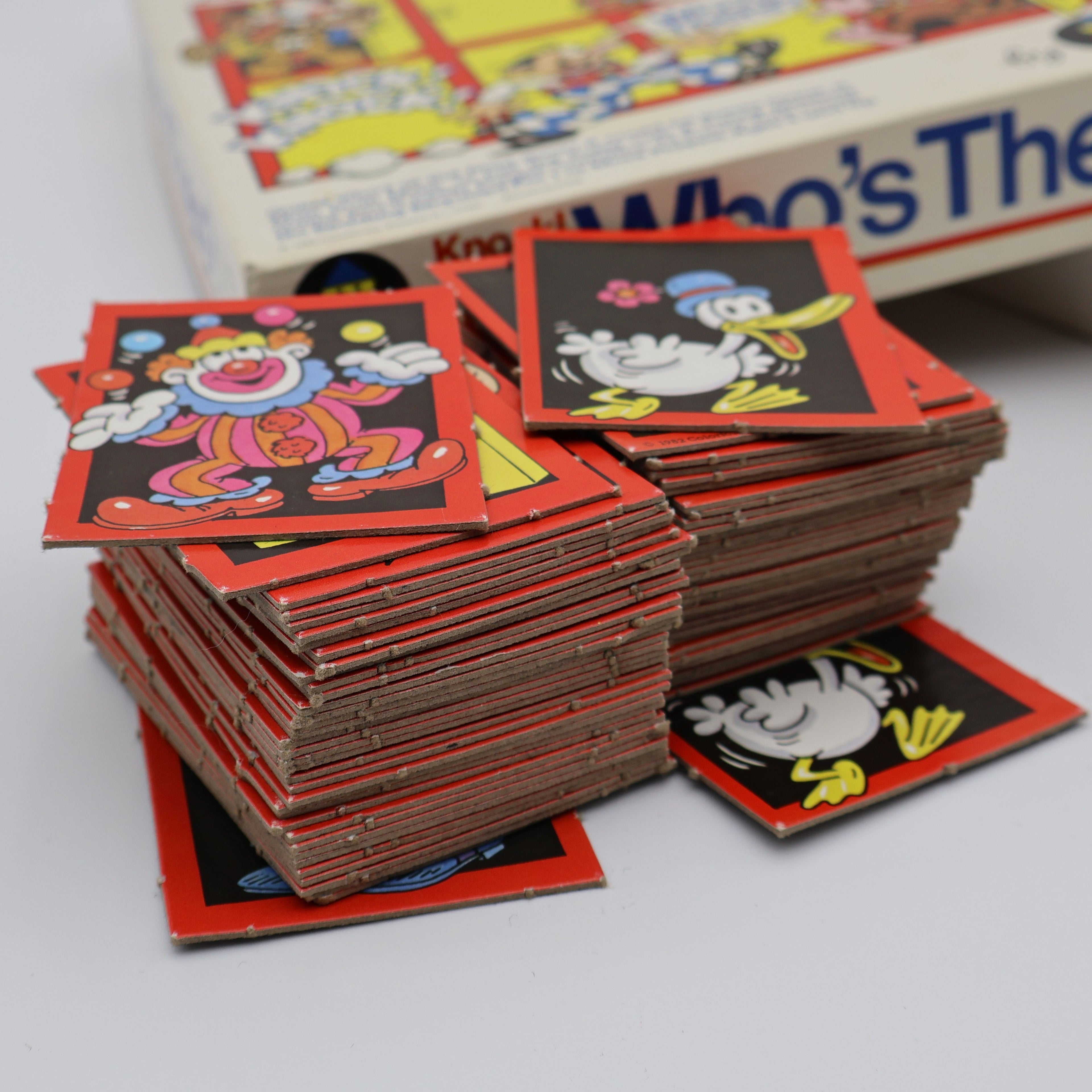 Stacked matching character cards from 1982 Colorforms Knock Knock Who’s There memory game showing vintage wear and red borders.