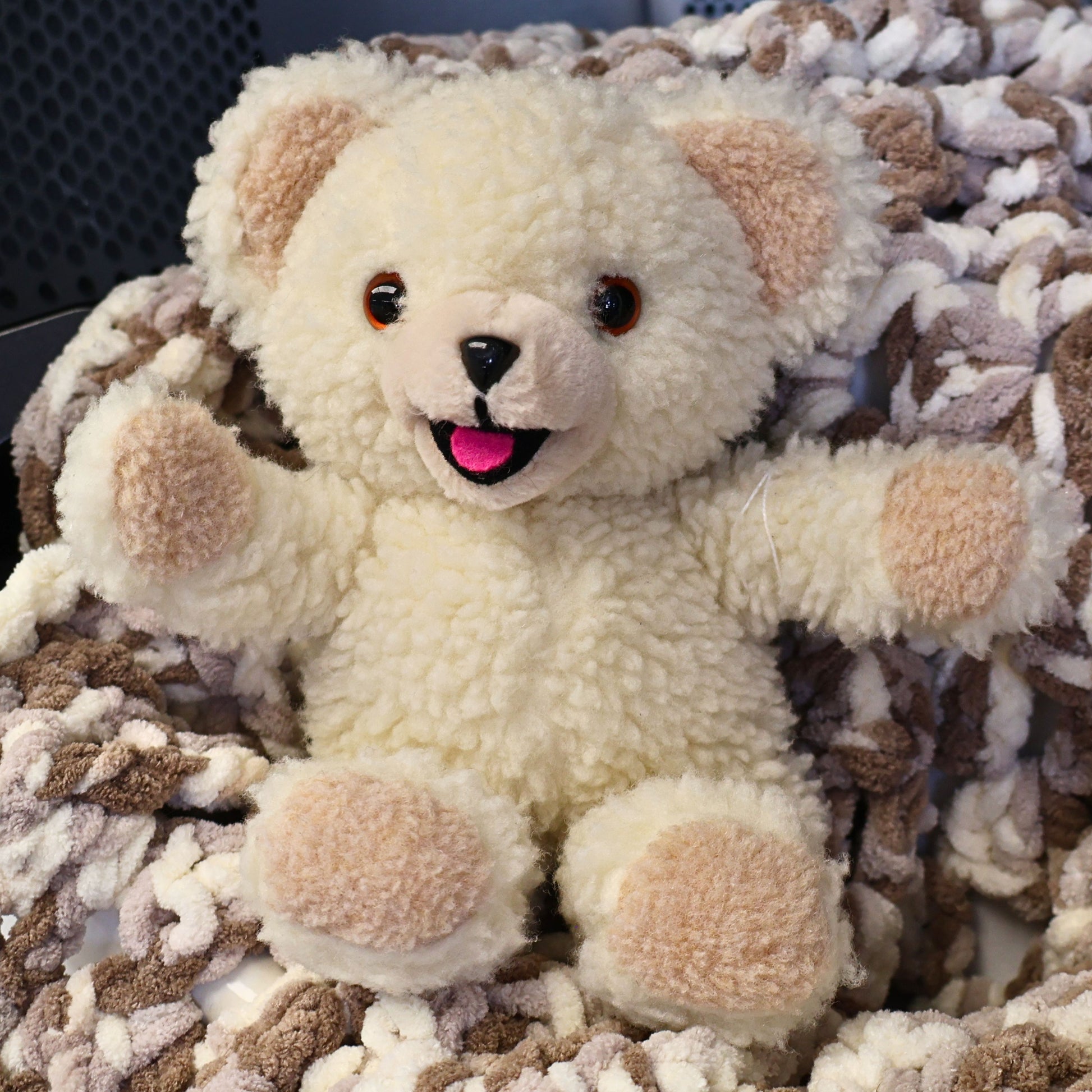 Authentic 1986 Snuggle fabric softener mascot plush with fluffy cream sherpa fur and smiling face. This vintage Lever Brothers advertising collectible is displayed seated on a cozy blanket and makes charming laundry room decor or a nostalgic collector's display piece.