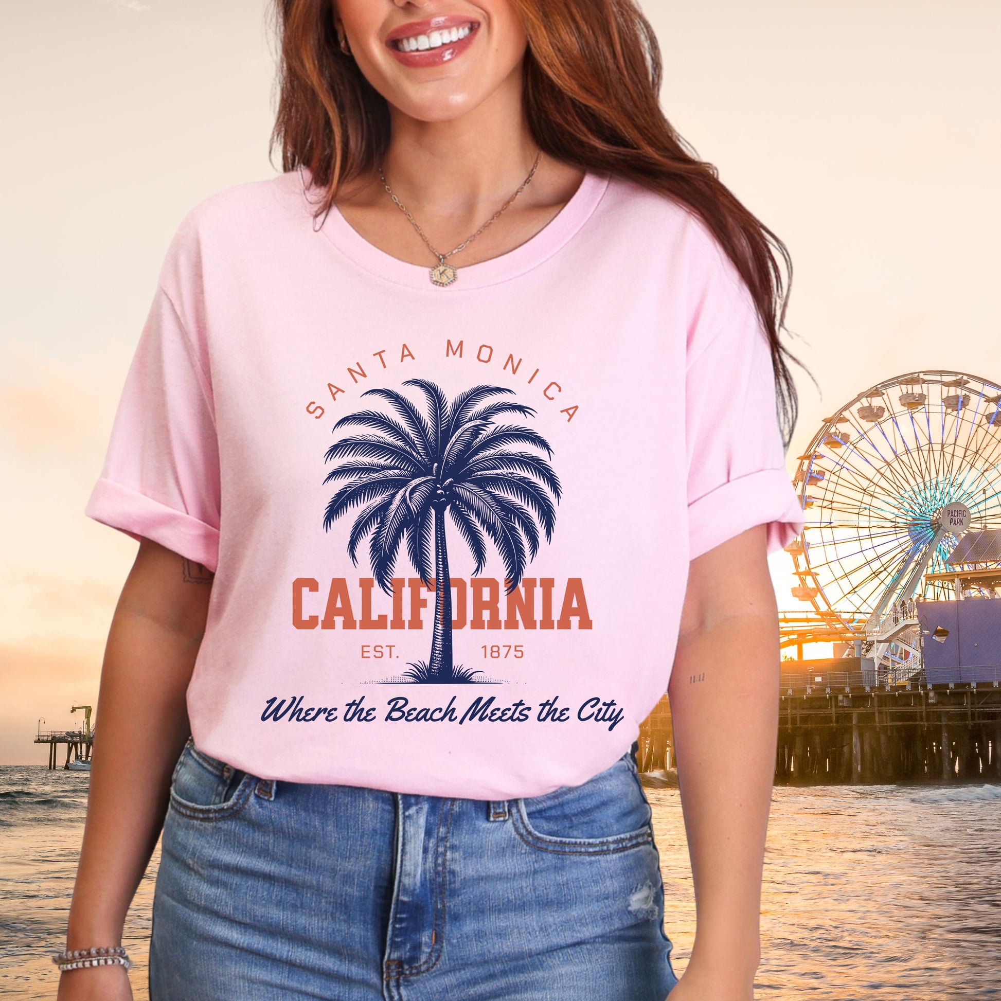 Person wearing a pink t-shirt with Santa Monica California design, ferris wheel in the background