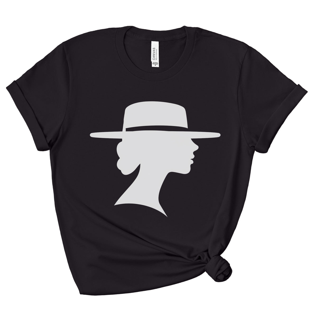 Black crewneck graphic tee with rolled sleeves and a knotted hem, shown flat against a white background. A light-colored silhouette depicts a woman in side profile wearing a wide-brimmed hat.