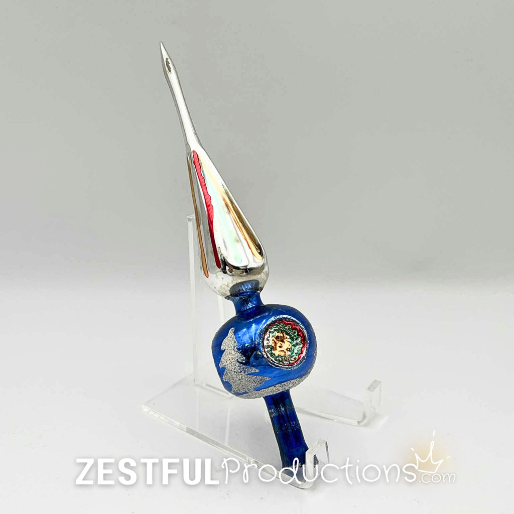 Vintage 1960s mercury glass Christmas tree topper displayed on acrylic stand featuring blue glass body, silver glitter accents, and retro holiday finial styling with original box included.