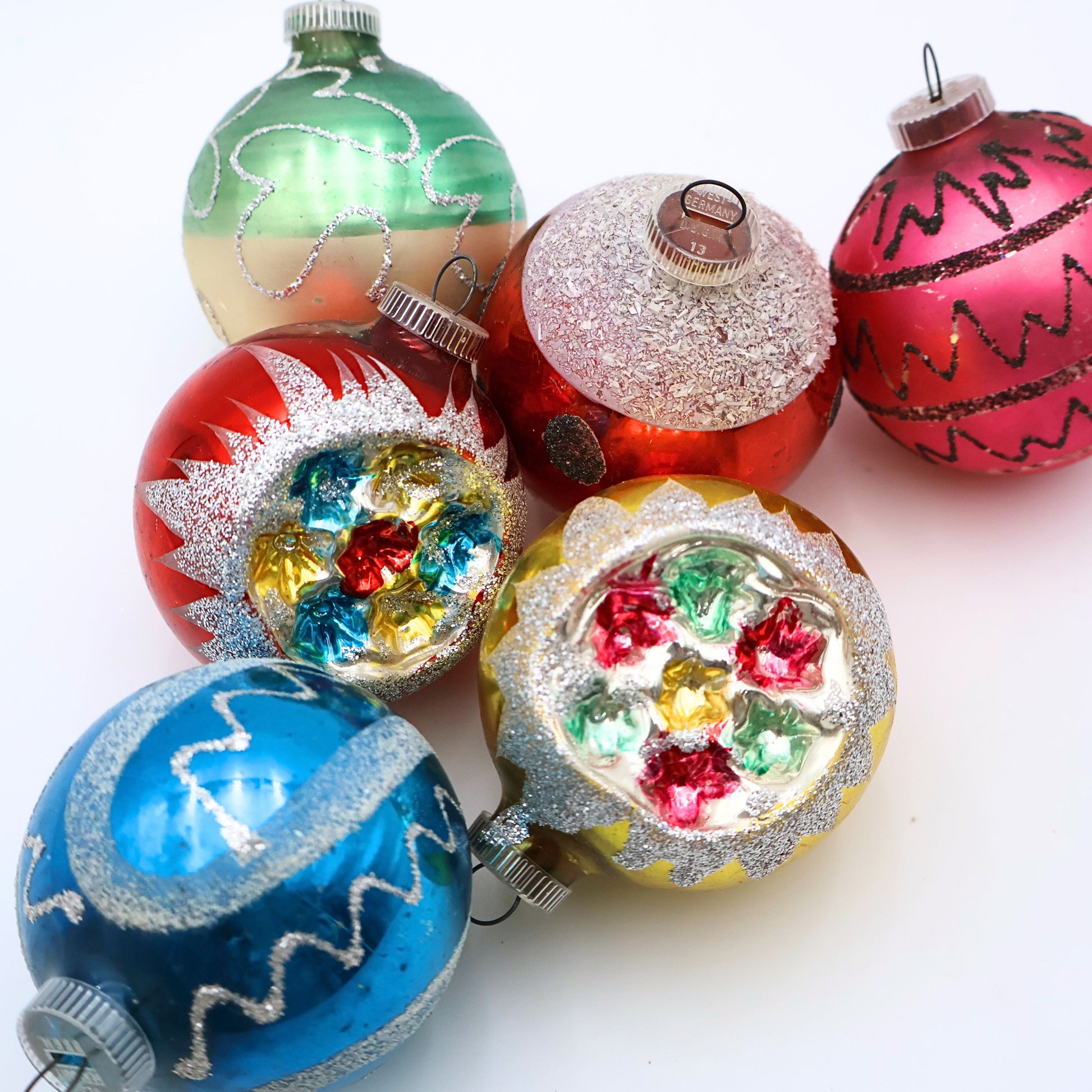 Styled grouping of vintage atomic reflector ornaments with colorful mercury glass finishes and retro Christmas decor styling