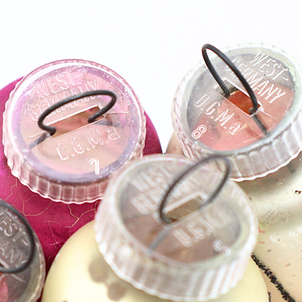 Macro detail of authentic West Germany ornament caps and vintage mercury glass Christmas ornament finishes