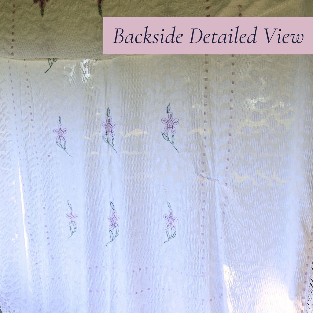 Backlit view of the vintage white chenille bedspread reveals the woven floral pattern, decorative border, and delicate lavender accents. This heirloom textile offers timeless appeal for farmhouse decor, cottage bedrooms, romantic bedding, and vintage home collections.