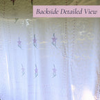 Backlit view of the vintage white chenille bedspread reveals the woven floral pattern, decorative border, and delicate lavender accents. This heirloom textile offers timeless appeal for farmhouse decor, cottage bedrooms, romantic bedding, and vintage home collections.