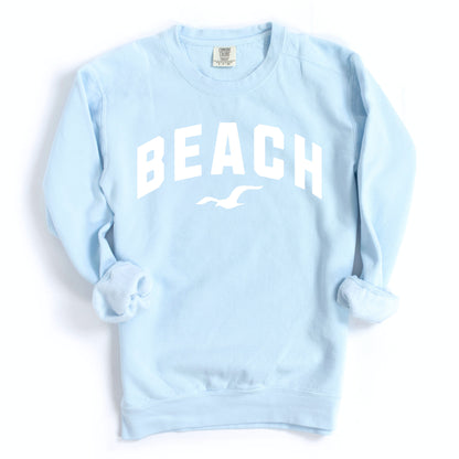 Light blue chambray beach crewneck sweatshirt flat lay, soft oversized fleece pullover with beach graphic, casual coastal outfit sweatshirt