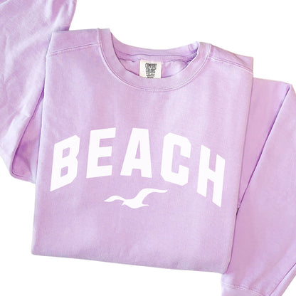 Orchid lavender beach crewneck sweatshirt flat lay, soft oversized fleece pullover with beach lettering, pastel coastal style sweatshirt
