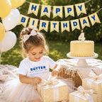 Toddler birthday girl wearing retro butter toddler tee at luxury outdoor birthday picnic with matching butter pennant banner and cake. Boutique foodie kids outfit styled for birthday parties, cake smash photos, and playful celebrations.
