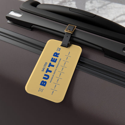 Butter luggage tag attached to suitcase handle in angled view. Durable and eye-catching travel accessory for easy bag identification at airports.