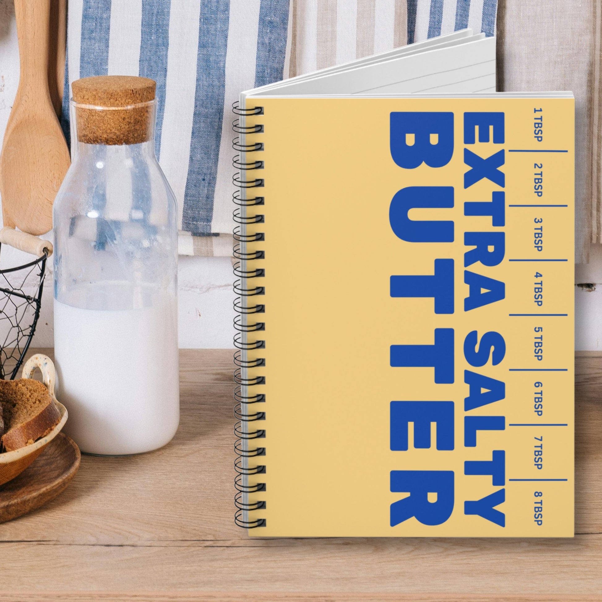 Close up of butter notebook cover with bold lettering and playful design. Spiral bound journal for writing, planning, and creative use.
