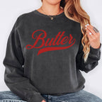 Black butter script crewneck sweatshirt styled in casual streetwear look. Bold vintage graphic pullover with relaxed fit. Ideal for everyday outfits and statement casual fashion.