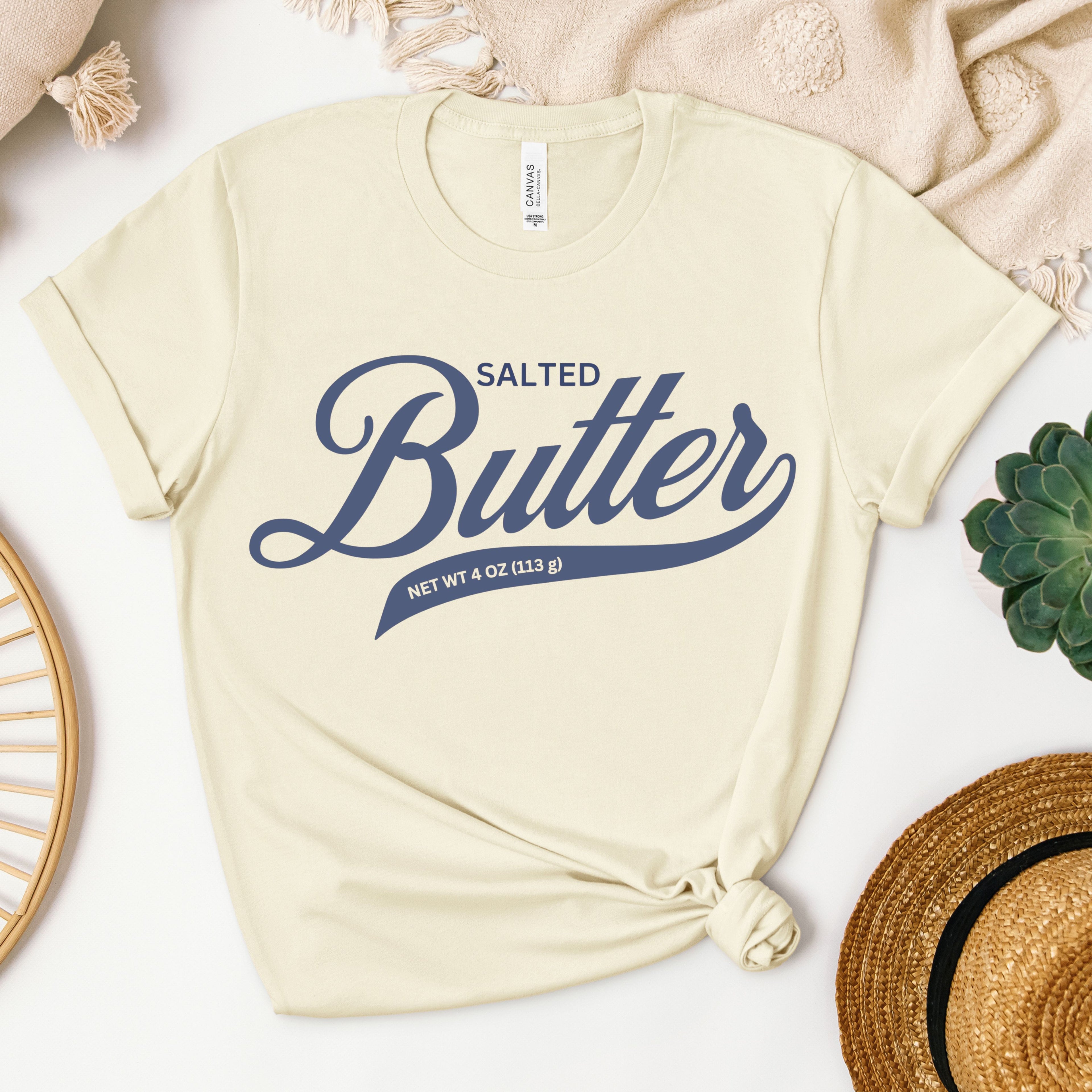 Soft cream butter script t shirt flat lay with minimal styling. Comfortable graphic tee with clean script design for butter lovers and relaxed outfits.