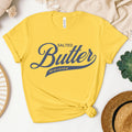 Butter script tee in yellow styled in casual outfit. Soft cotton graphic t shirt perfect for warm weather, relaxed looks, and everyday comfort.