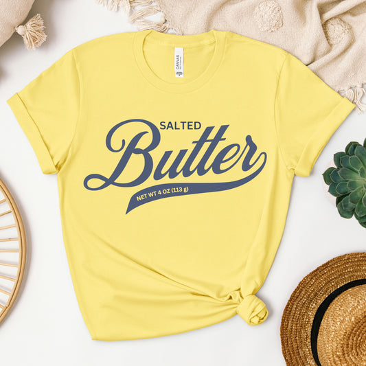 Yellow butter script graphic tee flat lay with bright bold lettering. Fun and eye catching t shirt for summer outfits, casual wear, and playful fashion lovers.