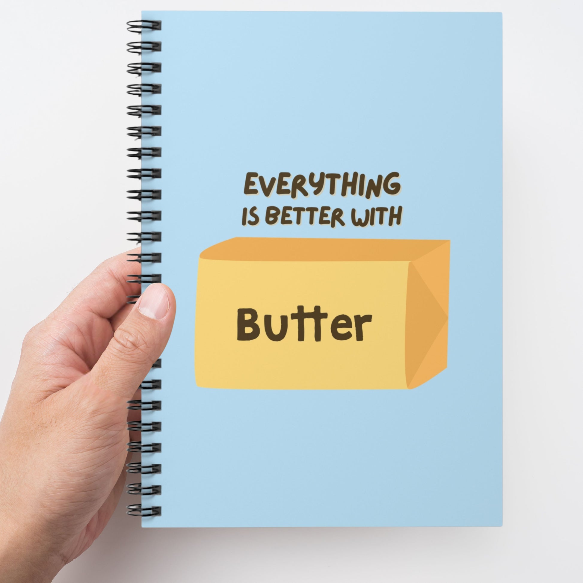 Butter spiral notebook held in hand showing blue cover design. Fun and functional journal for everyday writing and organization.