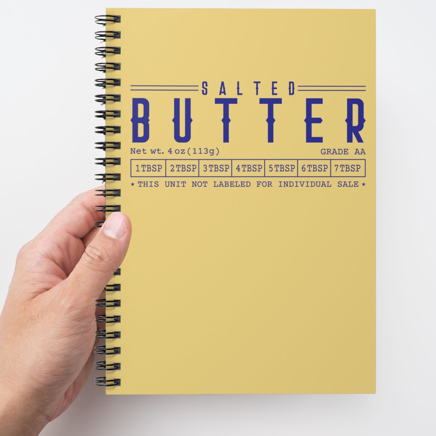 Butter spiral notebook held in hand showing bold yellow cover design. Functional journal for writing, organizing, and daily use.