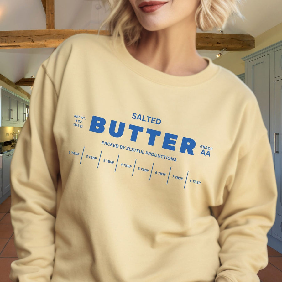 Woman wearing personalized butter sweatshirt in cozy indoor setting. Soft crewneck with butter graphic design styled casually.