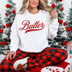 Butter script sweatshirt styled with festive plaid pants for cozy winter outfit. Vintage graphic crewneck perfect for holiday lounging, casual wear, and comfortable seasonal style.