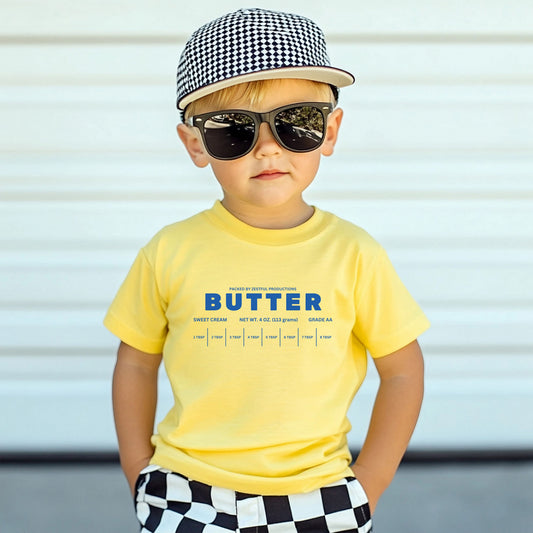 Toddler wearing yellow butter graphic tee with sunglasses and hat. Cute kids outfit with bold butter design, perfect for everyday wear, photos, and playful toddler style.
