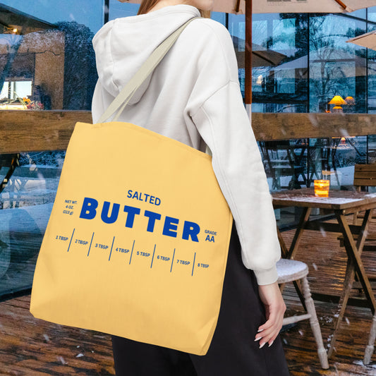 Butter tote bag carried in city setting with bold graphic design. Reusable everyday tote perfect for errands, shopping, and casual outfits.