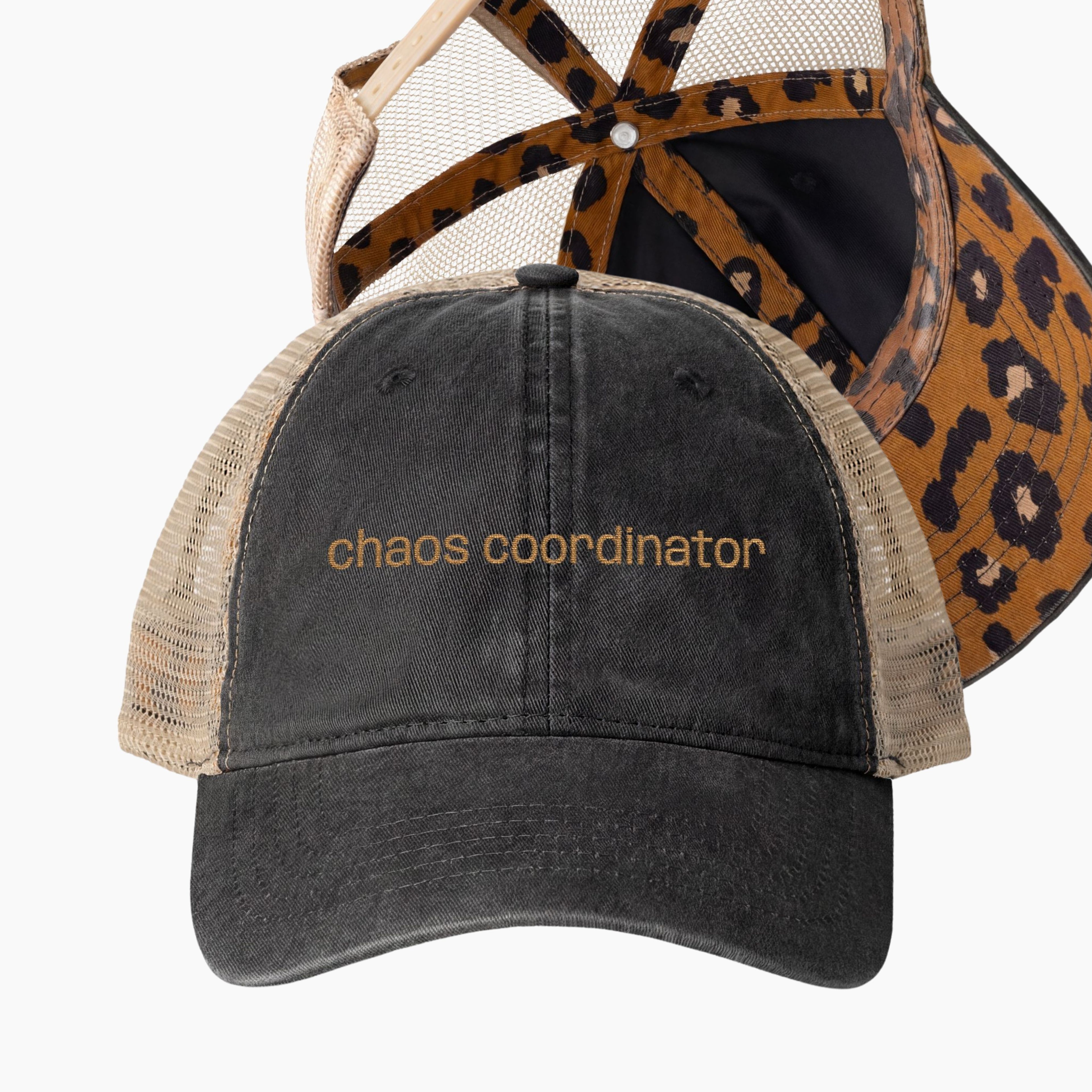 Washed black women’s trucker hat with chaos coordinator embroidery, tan mesh back, and leopard underbrim detail