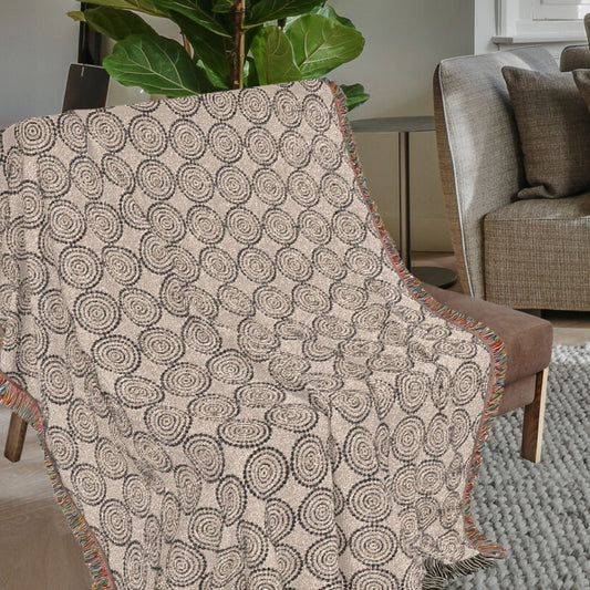 Circles woven cotton throw blanket draped over a chair with textured circular pattern