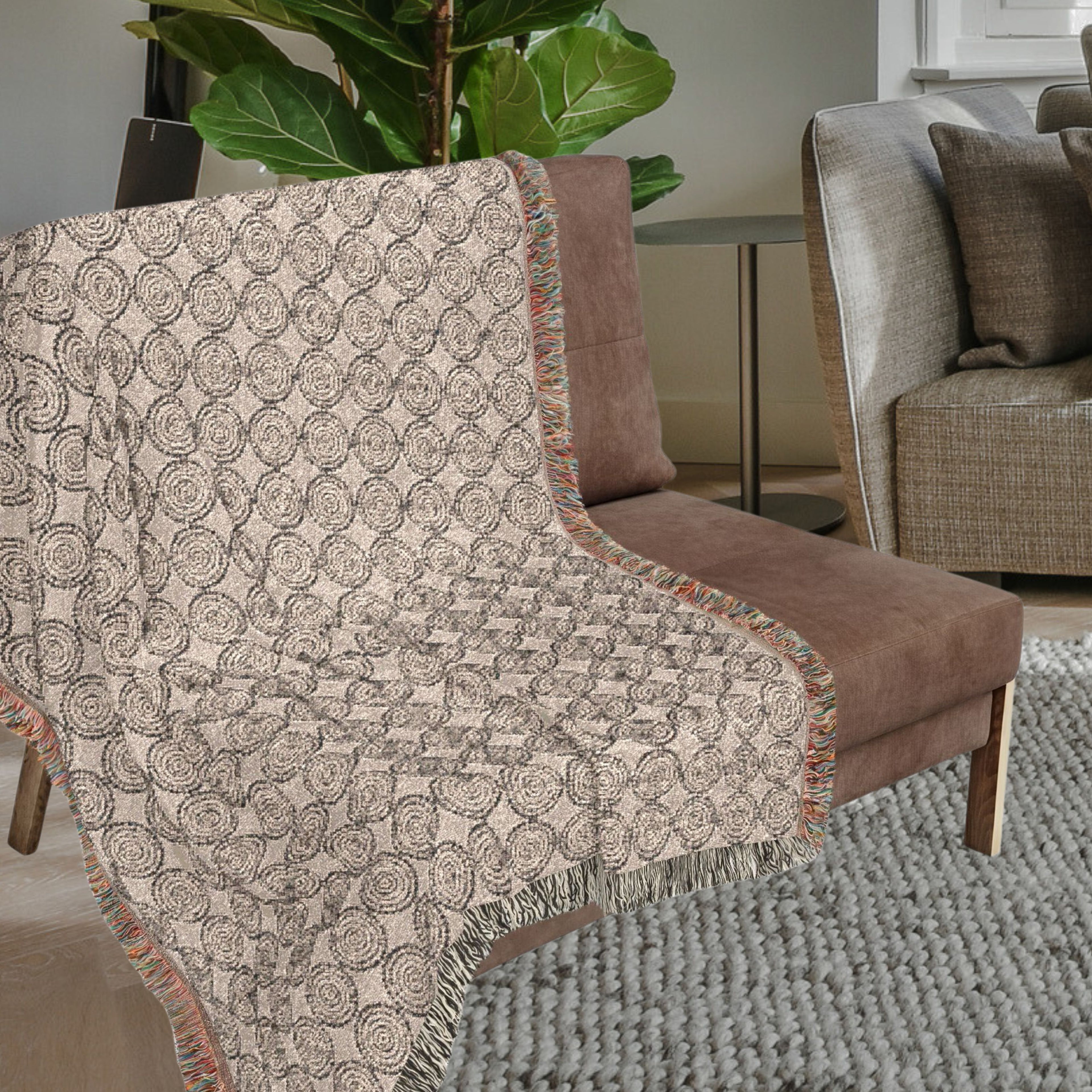 Close-up of woven cotton throw blanket showing circular pattern and fringe edges