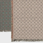 Close-up of woven cotton throw blanket showing circular pattern and fringe edges