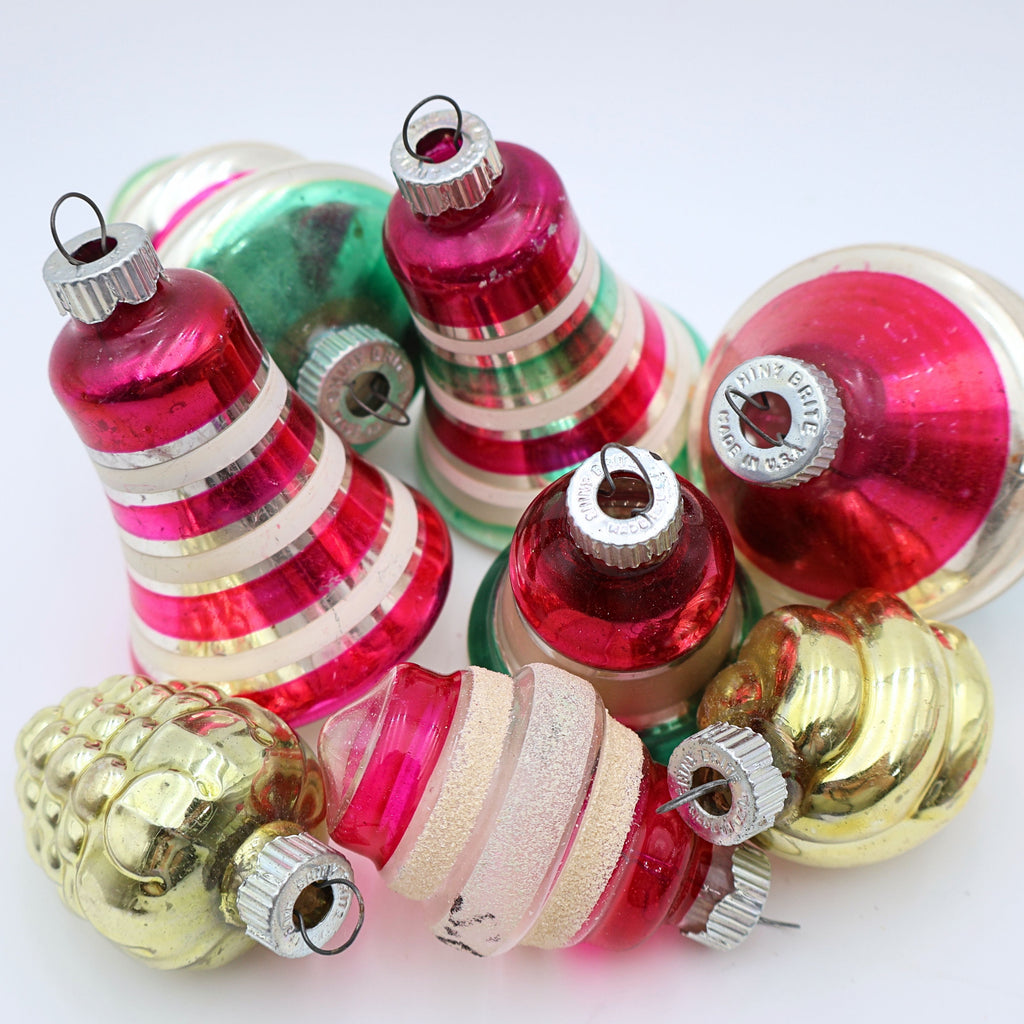 Closeup of striped vintage Shiny Brite style ornaments with red green pink and silver mercury glass details