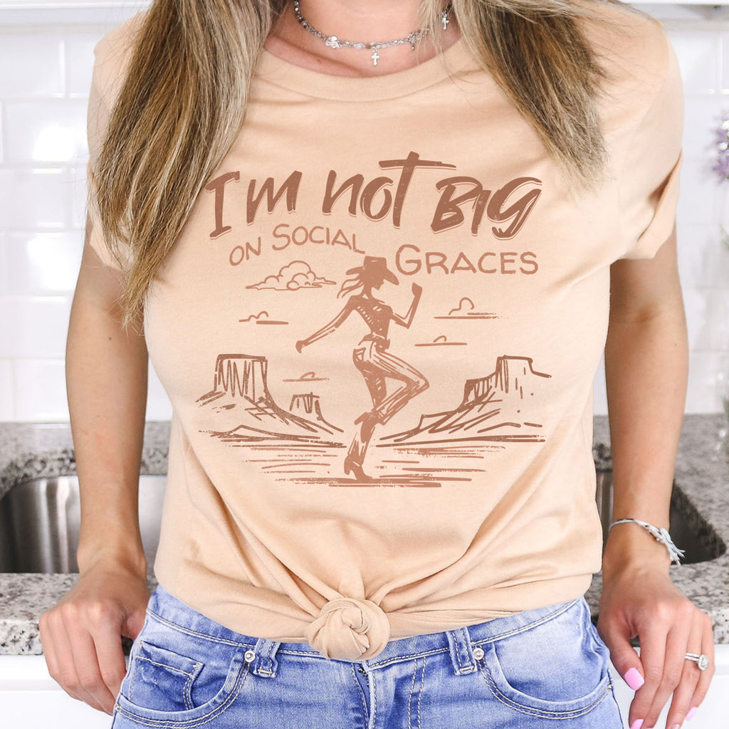 Western graphic tee styled on model with shorts for a casual outfit, featuring cowgirl desert illustration and soft neutral boutique aesthetic