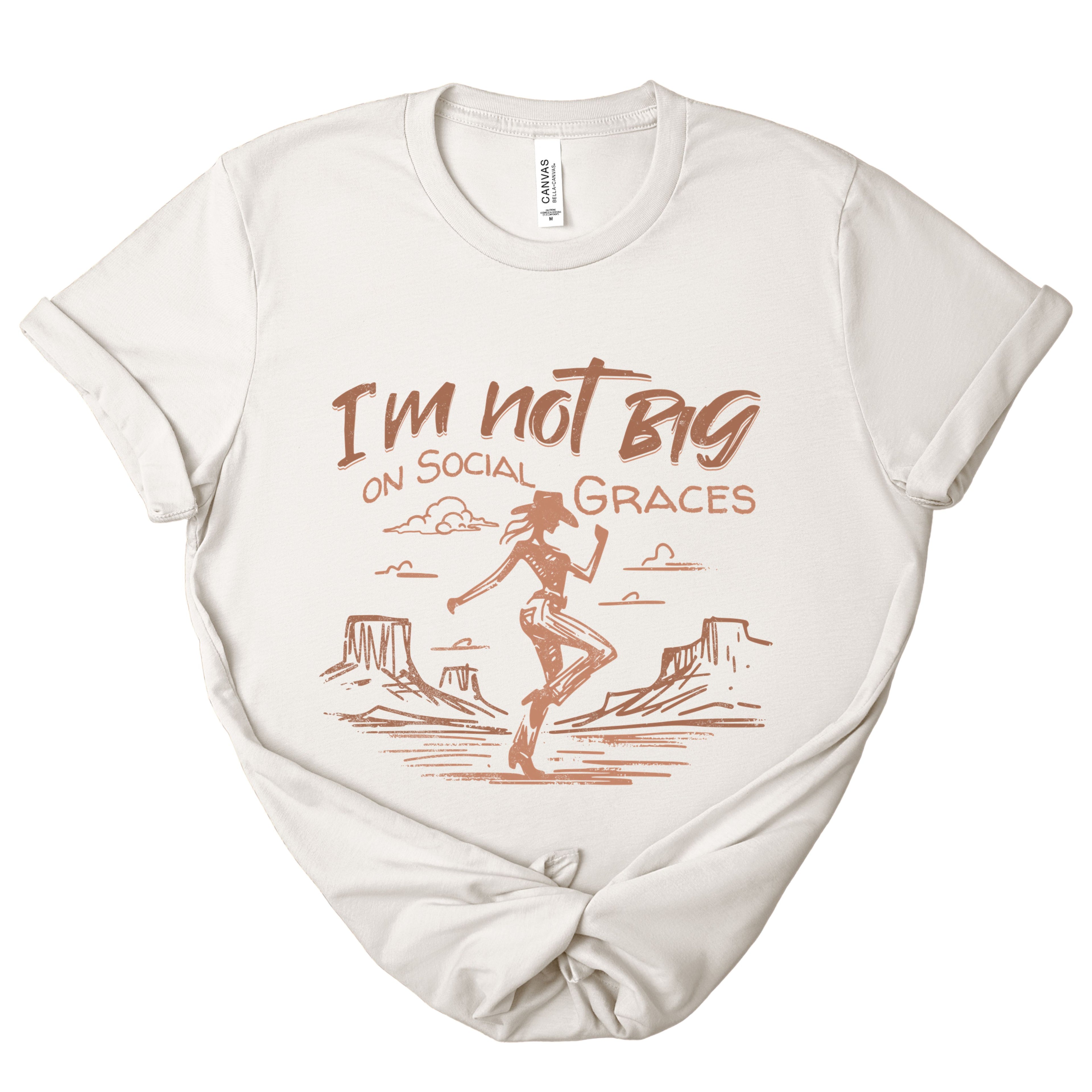 Vintage white western graphic tee with hand drawn cowgirl desert design and “I’m not big on social graces” phrase, soft neutral everyday boutique t-shirt