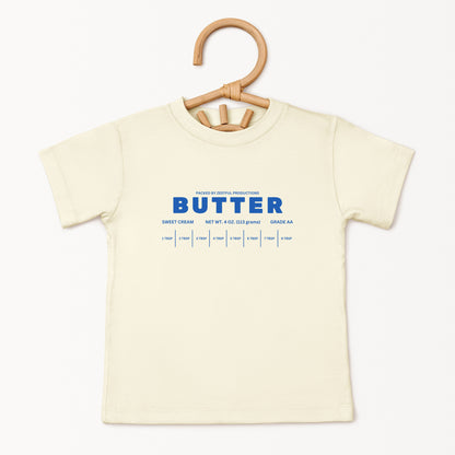Cream butter toddler tee displayed on hanger featuring retro sweet cream baking graphic and boutique foodie style. Trendy preschool apparel designed for birthdays, playful outfits, and aesthetic kids fashion.