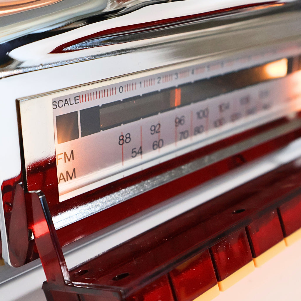 AM FM radio tuning dial on Crosley CR-9 jukebox style radio, vintage inspired frequency display with retro lighting, classic diner music player functionality detail