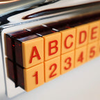Detail of Crosley CR-9 jukebox radio selection buttons with letter and number controls, retro 1950s diner style interface, nostalgic chrome music player with tactile push buttons