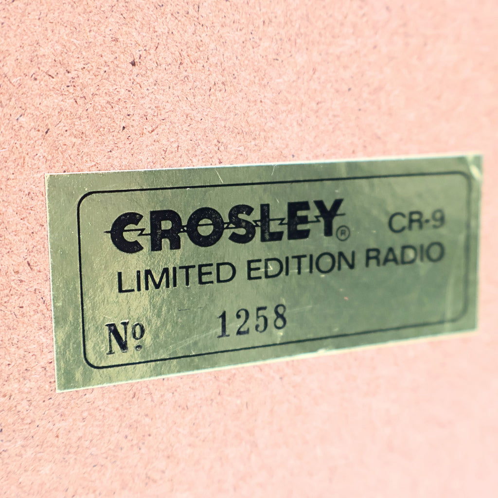Close up of Crosley CR-9 limited edition jukebox radio badge with serial number plate, collector’s edition marking on vintage style 1950s diner music player, chrome retro decor detail