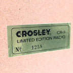 Close up of Crosley CR-9 limited edition jukebox radio badge with serial number plate, collector’s edition marking on vintage style 1950s diner music player, chrome retro decor detail