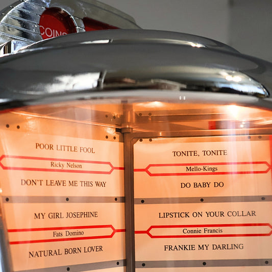 Close up of Crosley CR-9 Select-O-Matic jukebox radio song list display with classic track titles, illuminated rotating selector, nostalgic 1950s diner music player feature