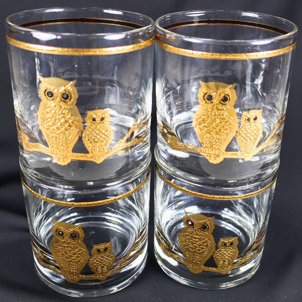 Four Culver owl lowball glasses arranged in a compact stacked display. The front-facing pair of clear tumblers shows textured gold adult and smaller owls perched together, with matching gold rim bands creating a cohesive mid-century barware set.