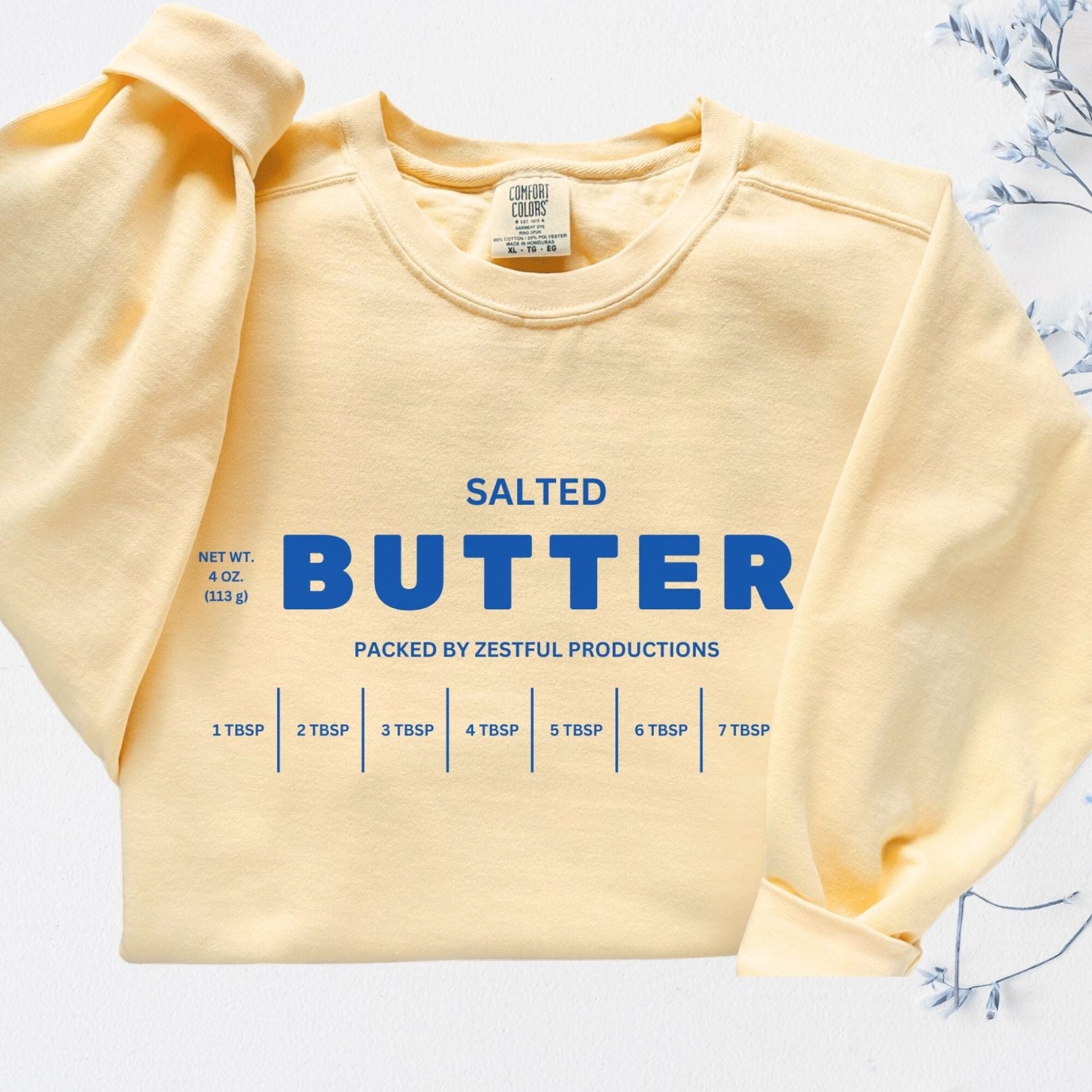 Folded personalized butter sweatshirt showing clean butter label graphic. Customizable cozy crewneck in soft garment dyed fabric.