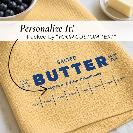 Close-up of personalized salted butter microfiber kitchen towel with custom text area, vintage butter packaging inspired design and tablespoon measurement markings. Funny culinary baker gift accessory for cooking enthusiasts and quirky yellow kitchen decor.