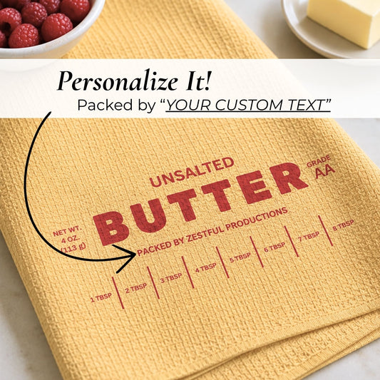 Close-up of personalized unsalted butter microfiber kitchen towel with custom text area, vintage butter packaging inspired design and tablespoon measurement lines. Funny culinary baker gift accessory for cooking enthusiasts and quirky yellow kitchen decor.