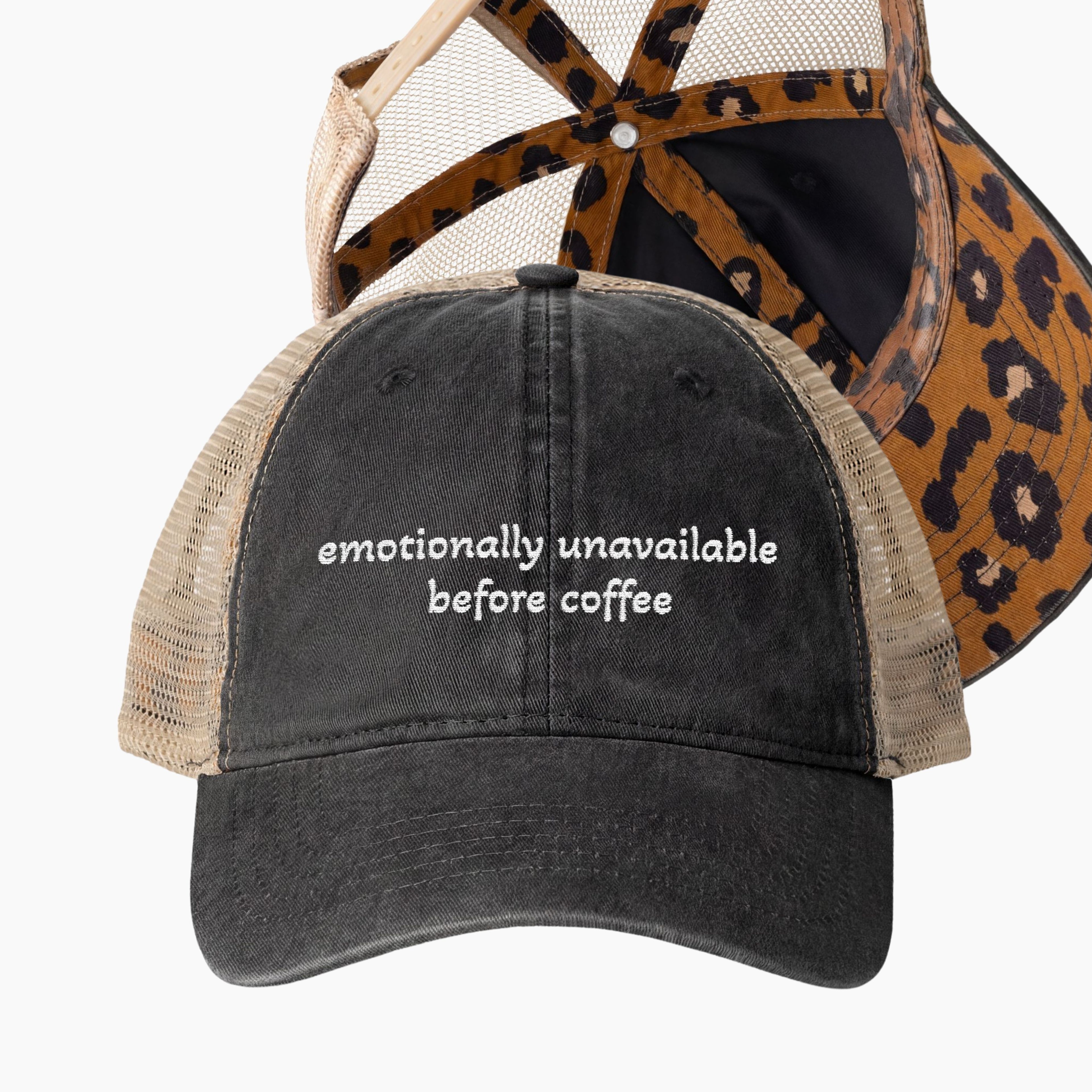 Washed black women’s ponytail trucker hat with emotionally unavailable before coffee embroidery and tan mesh back