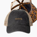 Washed black ponytail trucker hat with gold extra embroidery and hidden leopard print underbrim detail